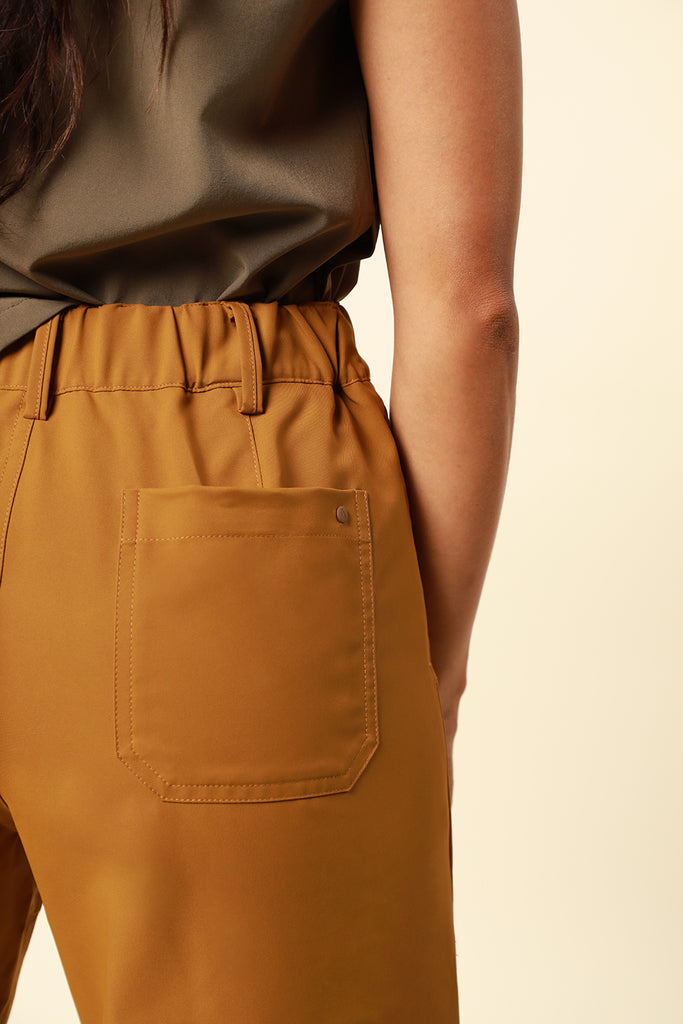 back pocket of the travel pants from wayre in bronze color